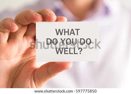 Closeup on businessman holding a card with WHAT DO YOU DO WELL ? message, business concept image with soft focus background