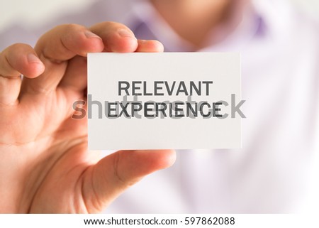 Closeup on businessman holding a card with RELEVANT EXPERIENCE message, business concept image with soft focus background