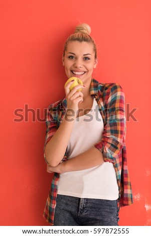 beautiful  young woman with hair bun plays with apple over color background with copyspace expressing different emotions