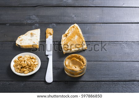 peanut butter sandwich, american breakfast and ingredients on old black wooden table background