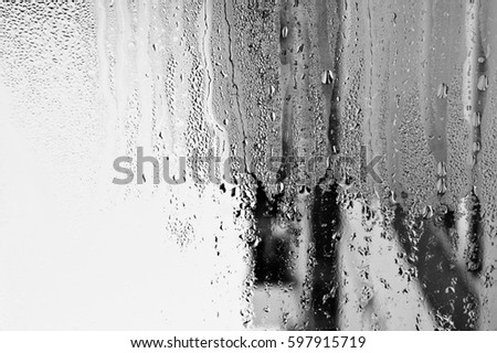 Blurry abstract background of foggy condensation on window glass natural surface. Grey glass texture wallpaper.