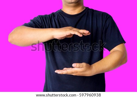A man with casual wear hold with a both hand isolated over pink background with copy space for add word text title or logo. 