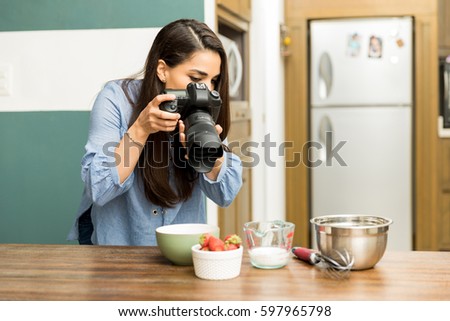 Young professional photographer taking some pictures of food in a kitchen
