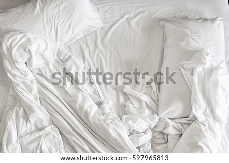 Top view of unmade bedding sheets and pillow Royalty-Free Stock Photo #597965813