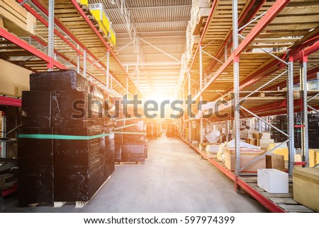 Warehouse industrial and logistics companies. The boxes on high shelves stocked. Many boxes packed in a black stretch film. Bright sunlight.