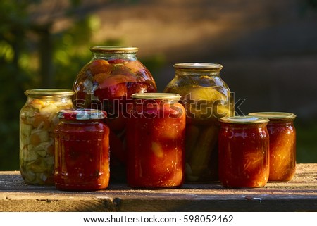 Jars of pickled vegetables on the stock during sunset.