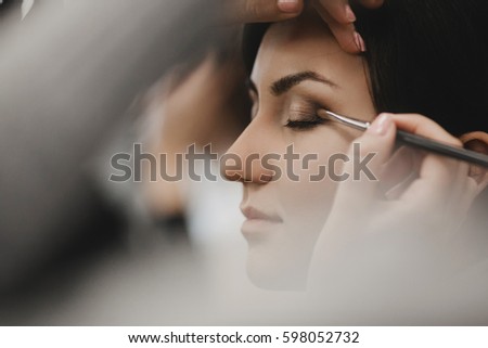 The makeup artist doing a makeup for bride Royalty-Free Stock Photo #598052732