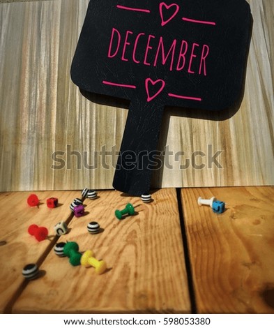 DECEMBER word on the blackboard with wooden background and colorful cubes on wooden board