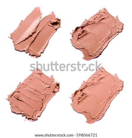 Beige smears of crushed lipstick on a white background. 