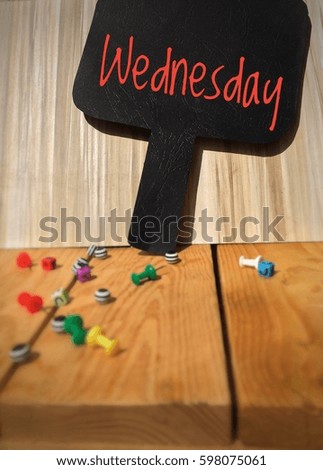 WEDNESDAY word on the blackboard with wooden background and colorful cubes on wooden board