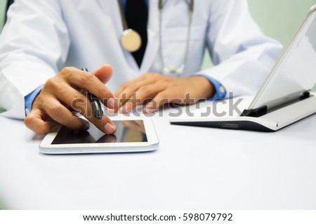medicine doctor working with computer notebook and digital tablet  at desk in the hospital