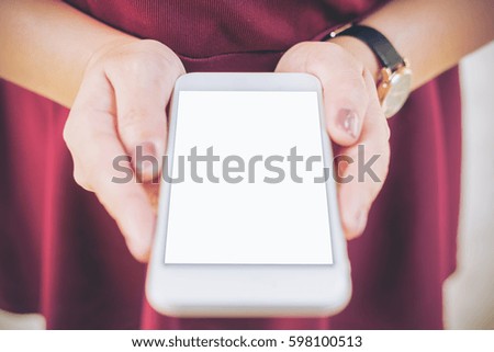Mockup image of a woman holding white mobile phone with blank white screen   