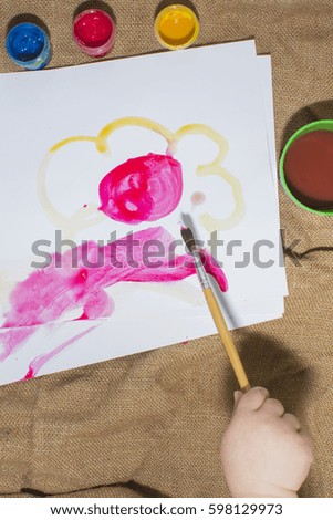Brush and colorful paints on a child's picture