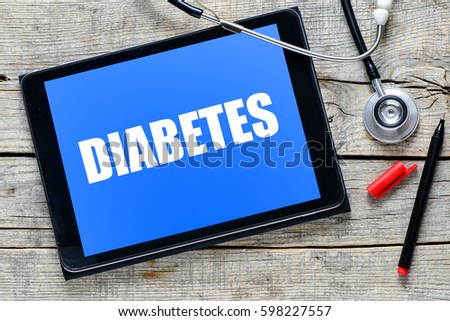 Diabetes on tablet pc with stethoscope on wooden background
