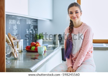 Young woman sitting near table in the kitchen