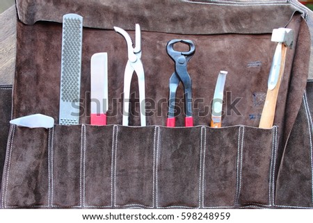 Horse shoeing tools hammer pullers tacks file Royalty-Free Stock Photo #598248959