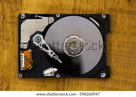 Opened hard drive from the computer on wooden background.