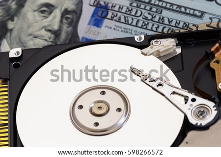 disassembled hard drive  on money background. Concept of data recovery.