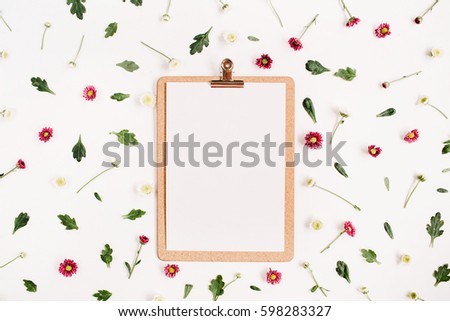 Clipboard mock up and wildflower pattern. Flat lay, top view. Flower background.