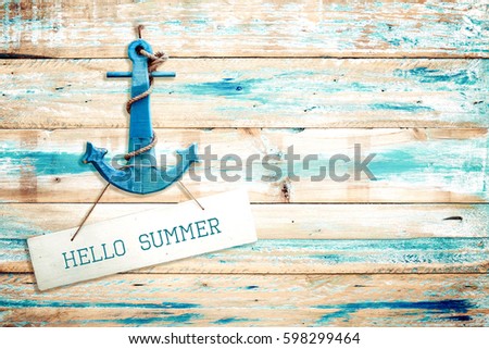 Vintage Hello summer sign hanging with anchor on old wooden blue paint background. vintage wood texture from beach in summer.