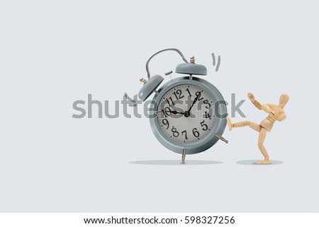 Wooden dummy kick a big clock, Isolated on blue background, Idea and concept of time picture.
