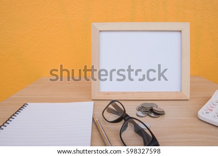 Business on financial report . photo Frame and coin on a wooden on Yellow background . 