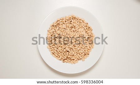 TOP VIEW: Dried white beans on a white dish
