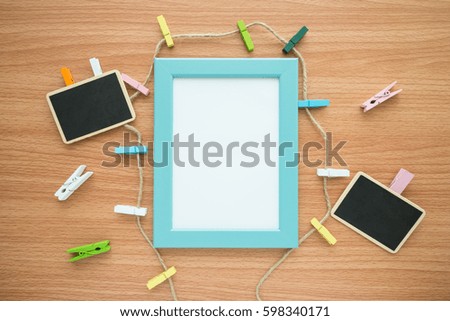 Flat lay of blue photo frame and stationery mockup on wooden table for creative design concept