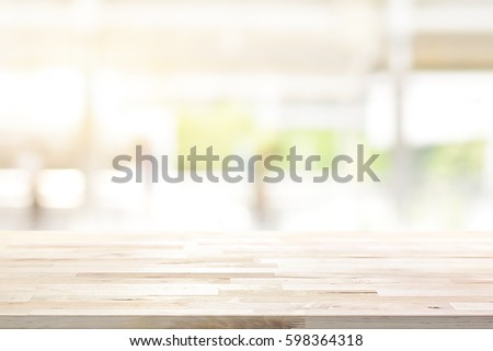 Wood table top on blur kitchen window background - can be used for display or montage your products (foods)