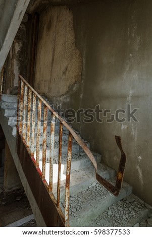 Old destroyed concrete, stone staircase in interior of ruins of unfinished administrative building of business center. Ruined old staircase in interior of abandoned factory building. Trash industrial