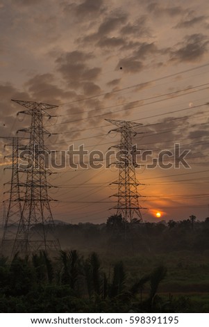 a high voltage transmission line across a field at Tanjung Pelepas views during dramatic sunrise