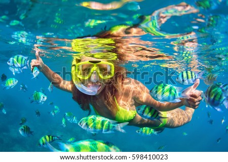 Happy family - girl in snorkeling mask dive underwater with fishes school in coral reef sea pool. Travel lifestyle, water sport outdoor adventure, swimming lessons on summer beach holidays with child. Royalty-Free Stock Photo #598410023