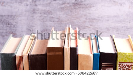 Old books on a shelf over grey background