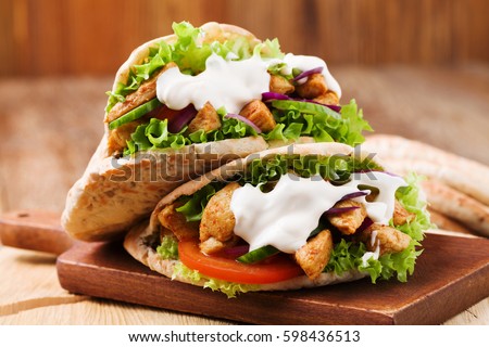 Pita salad with roasted chicken and vegetables, served with a delicious sauce Royalty-Free Stock Photo #598436513