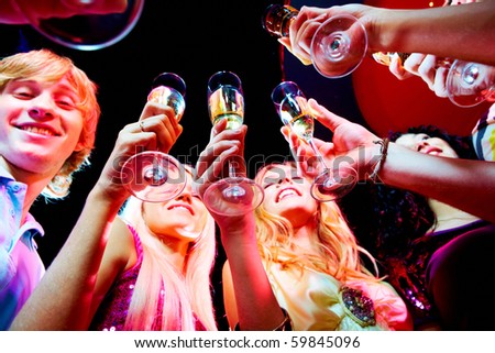 Image of boozing young people with champagne flutes toasting at party