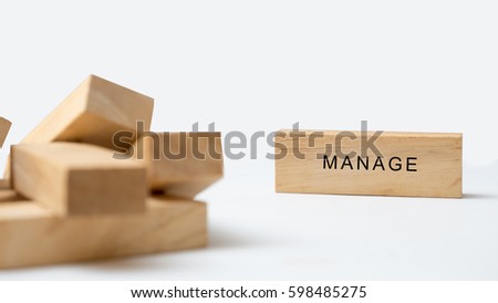 manage word written on wood block close up on white background