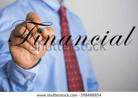 Businessman writing FINANCIAL on virtual screen.