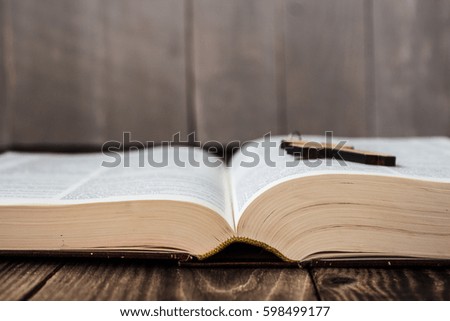 a christian cross and bible on wooden background