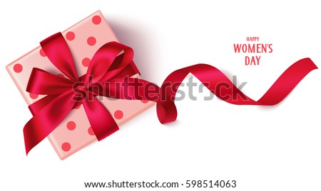 Decorative gift box with red bow and long ribbon. Happy Women's Day text. Top view Royalty-Free Stock Photo #598514063
