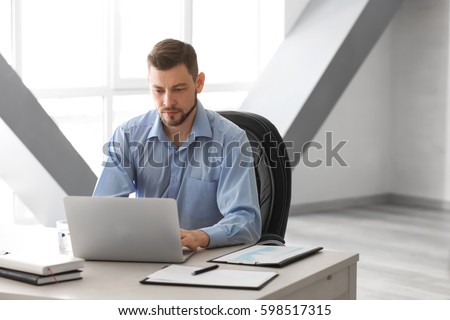 Handsome manager working with laptop in office Royalty-Free Stock Photo #598517315