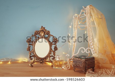 Antique blank victorian style frame on wooden table. Ready to put photography