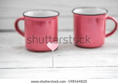 beautiful pink Cup with heart on a stick on a light wooden background, concept drinks