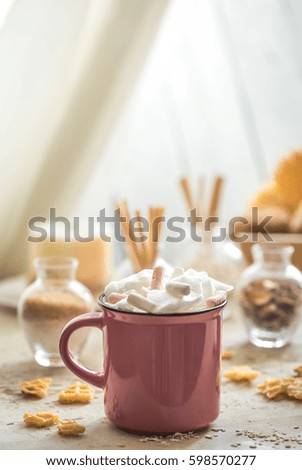 a delicious Cup of cocoa with colorful marshmallows and candies on a light wooden background,concept drinks and relaxing weekend