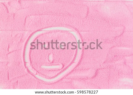 Smiley painted on decorative sand on the table. Children's educational creative concept.