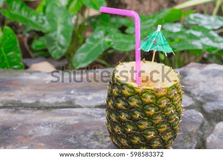 Exotic cocktail in a pineapple on a nature background