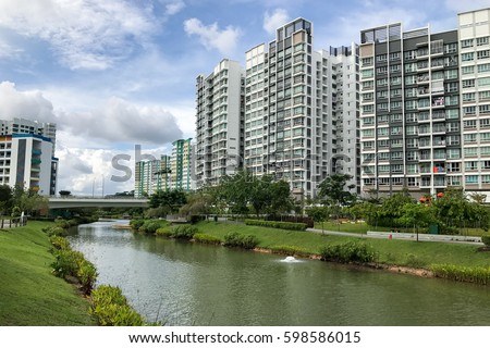 Singapore Public Housing Apartments in Punggol District, Singapore. Housing Development Board(HDB). Punggol is planning area and new town in North-East region of Singapore, canal and condominiums. Royalty-Free Stock Photo #598586015