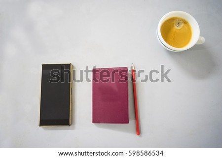 top view of smartphone, notebook, pencil and a cup of espresso with some blank space for editing and retouching