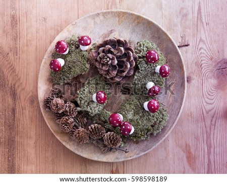 wooden bowl  with pinecones and moss and mushrooms on wooden table