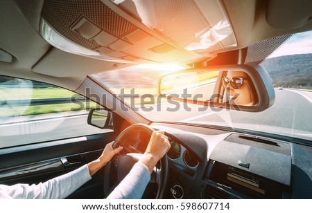 Woman drive a car reflects in back view mirror Royalty-Free Stock Photo #598607714
