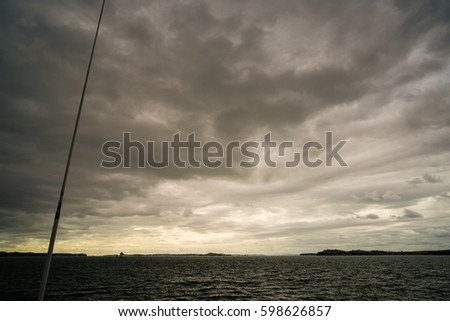 Dramatic dark cloudy sky over sea, natural photo background.